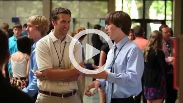 A play button is superimposed above a man and a teen standing talking.